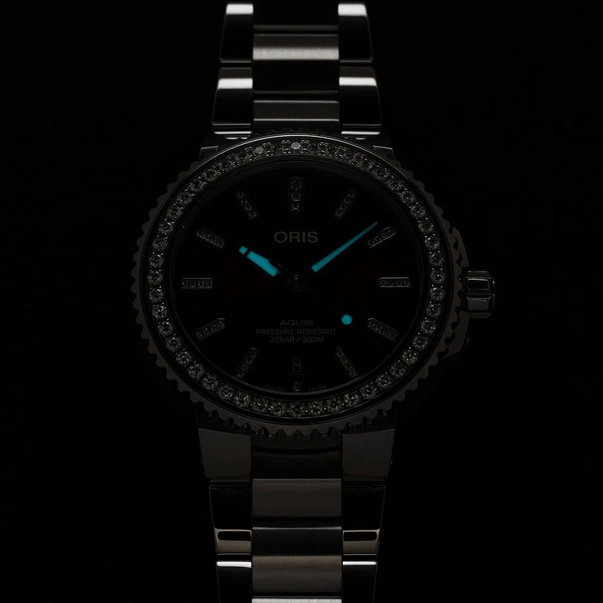 Lume display of the Oris Aquis Date Relief 41.50cmm Automatic Watch 733 7766 4998MB, showing the Superluminova-treated hands and indices illuminated for readability in low-light conditions.