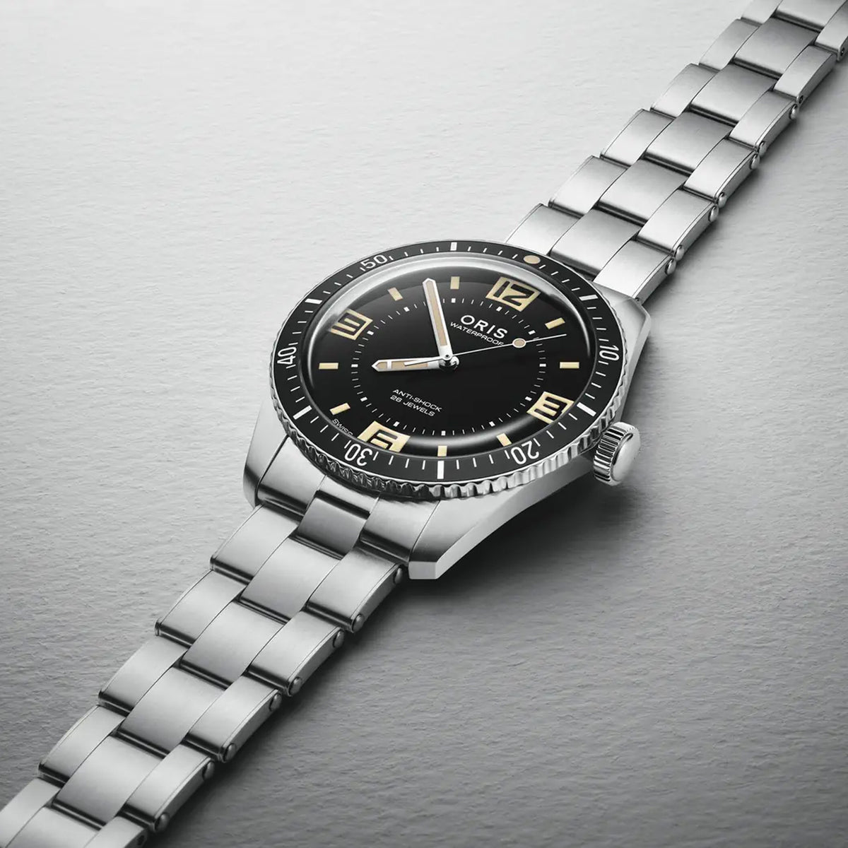 Close-up of the black dial on the Oris Sixty Five Automatic Men's 40mm Watch 733 7772 4034SET, showing the large luminescent numerals and retro Oris logo. The polished bezel and case finish are shown in detail.