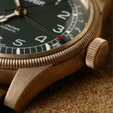 Close-up of the green dial on the Oris Big Crown Limited Edition Men's 40mm Bronze Automatic Watch 754 7741 3167LS, showing the Arabic numeral hour markers and red-tipped pointer date hand. The polished bronze bezel and case finish are shown in detail.