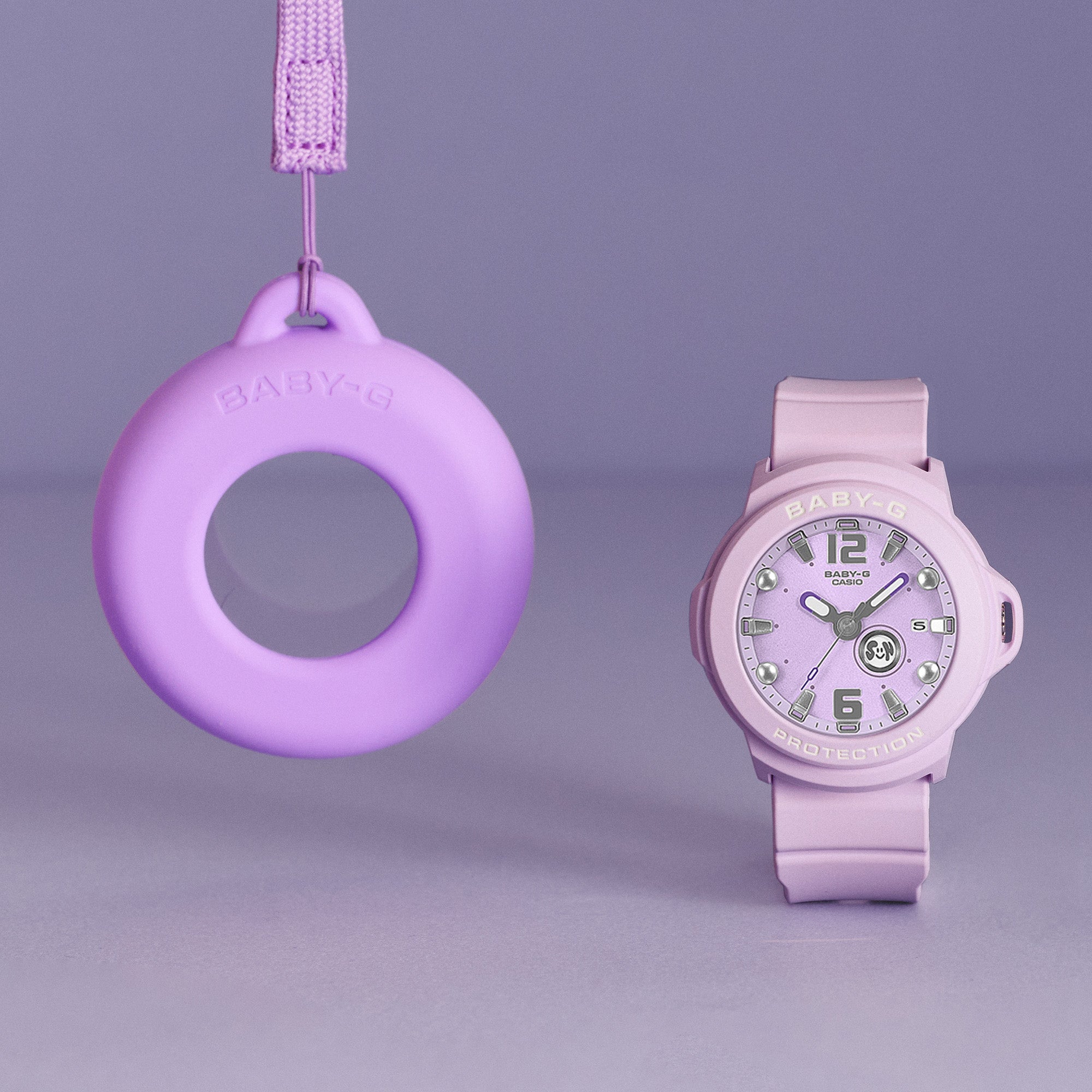 Casio Baby-G+PLUS BGA15K-6A front view — soft purple matte round resin case, shimmering metal dial, Arabic numerals, three-hand analogue display with rotating day design. 43.5mm x 42.4mm, 35 grams, shock resistant, 100M water resistant.