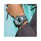 Casio G-SHOCK DW6900HD-8D digital watch with grey resin band, black LCD display, triple graph face, and shock-resistant design - on wrist
