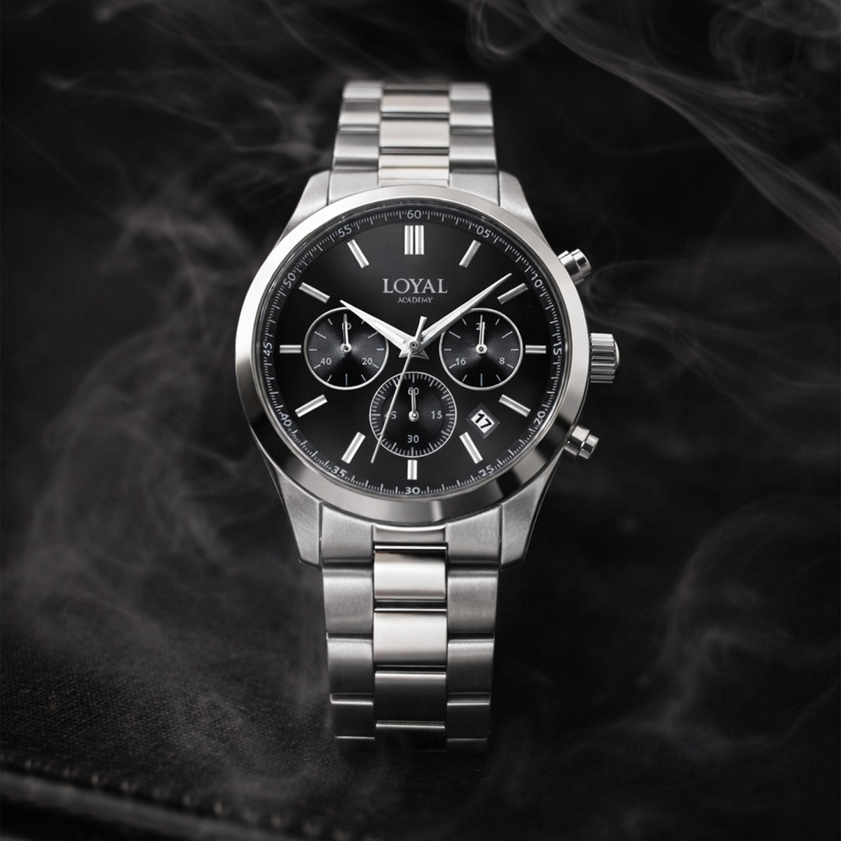 The Loyal Academy Steel Chronograph Watch features a black dial with chronograph sub-dials, framed by a stainless steel case, reference 03R85MBZ1. This 40mm quartz watch pairs a stainless steel bracelet with a mineral glass lens and 100m water resistance.