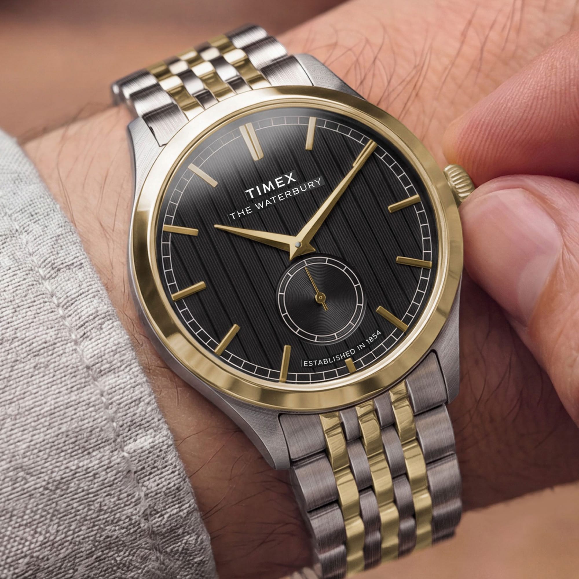 The Timex Waterbury Traditional Quartz 39mm Watch TW2Y91900 pairs its polished stainless steel case with a two-tone stainless steel bracelet for a fully steel, considered look. The gold-tone accents add warmth against the two-tone bracelet.