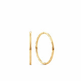 A pair of 9ct yellow gold sleeper hoop earrings zi shown front on, displaying their compact 10mm round silhouette with a polished finish and slim 1mm width.
