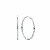 A pair of sterling silver sleeper hoop earrings shown front on, displaying their medium 13mm round silhouette. Crafted from solid silver, they're a durable, everyday style suitable for children.