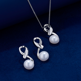 The Wallace Bishop Pearl & Sterling Silver Pendant and Earrings Set, reference 33PSET006, laid out on a deep blue velvet surface. The pendant hangs from a fine chain and each earring has a polished silver twist design with a round white pearl at the base.