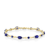 Front-on view of the Wallace Bishop 0.06 TDW Created Sapphire & Diamond Bracelet in 9ct Yellow Gold, reference 34BLS16, 180mm in length with a lobster clasp. Dark blue oval and round created sapphires alternate along the polished gold links, with small round diamonds between them.
