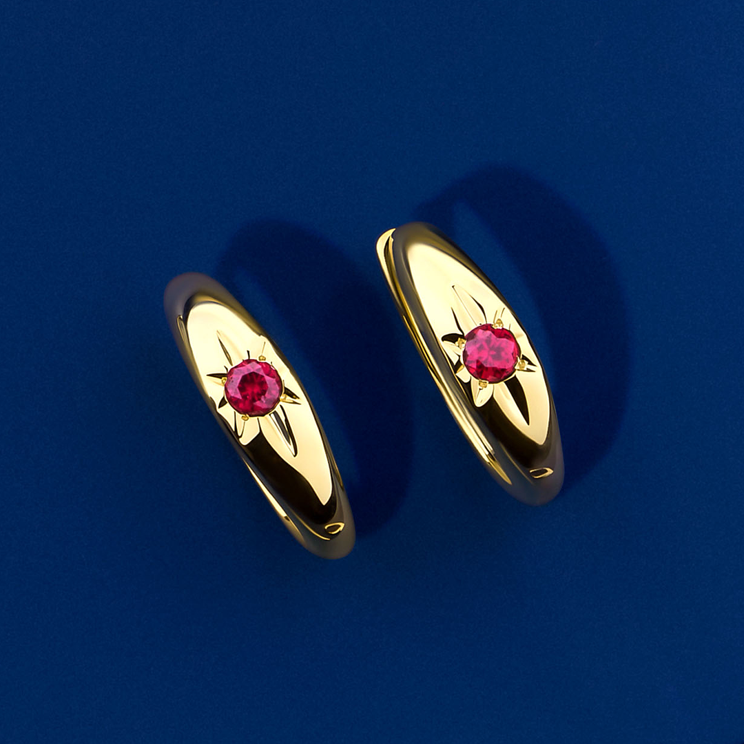 Front-on view of the Wallace Bishop Created Ruby Starburst Huggies in 9ct Yellow Gold, reference 34ERSBRY, measuring 14.50mm in length. Each huggie holds a 2.5mm round created ruby in a star hammer setting.