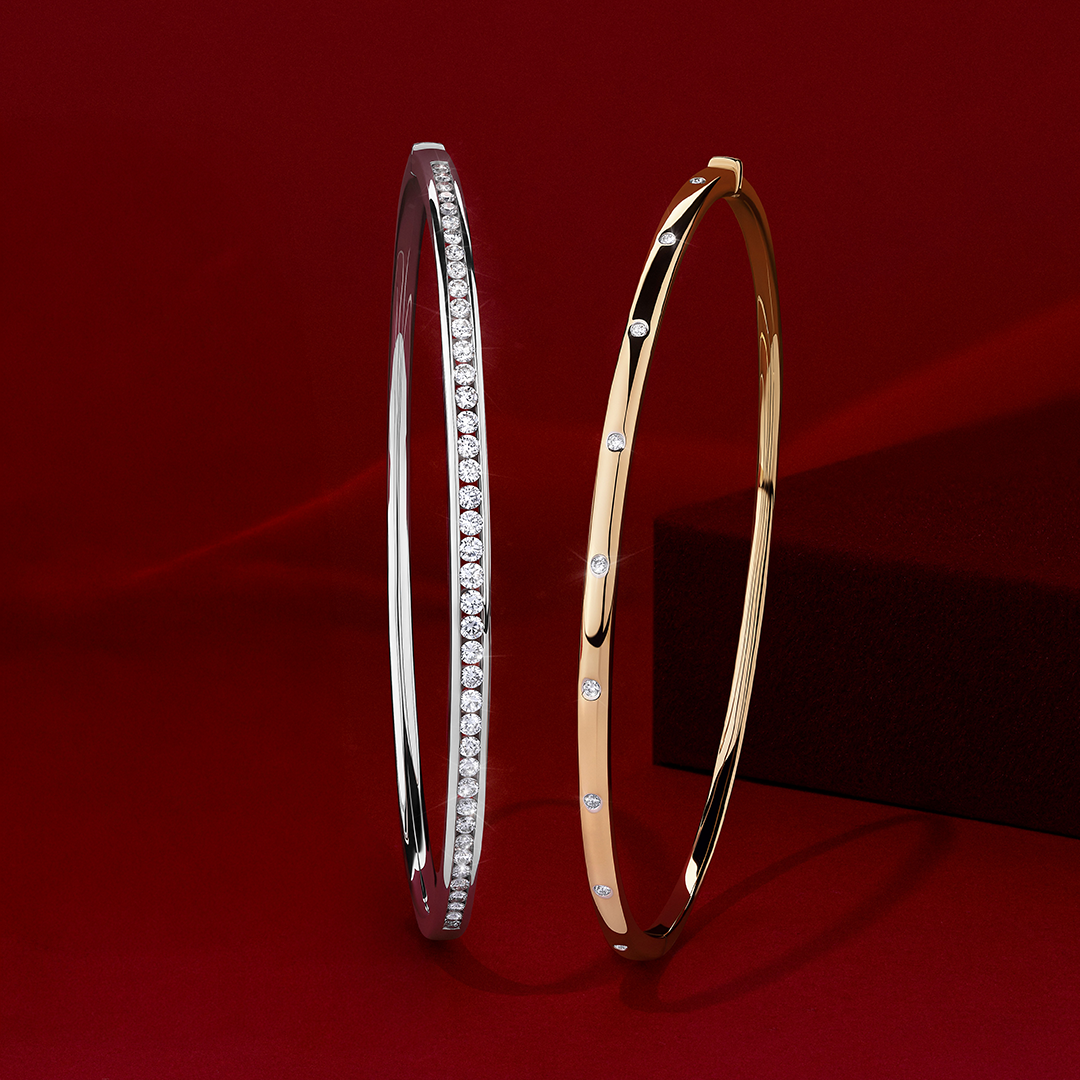 Front-on view of two Wallace Bishop diamond bangles: the 0.15 TDW Hammerset Diamond Bangle in 9ct Yellow Gold, reference 3BHSB01Y, and the 0.50 TW Diamond Bangle in 9ct White Gold, reference 3BG050DW.