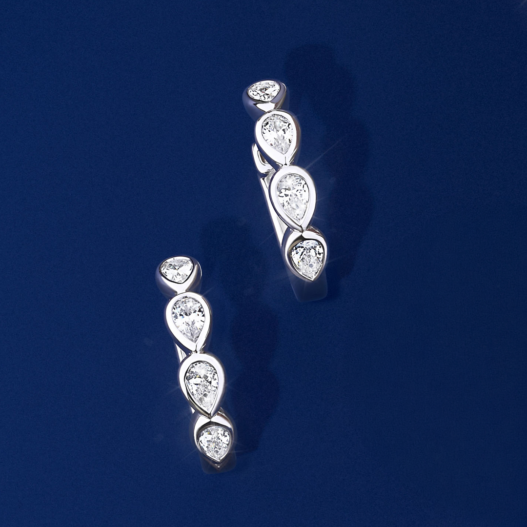 Front-on view of the Wallace Bishop Cubic Zirconia Bezel Huggies in Sterling Silver, reference 41PSBCZE3. Each petite huggie features bezel-set pear cut white cubic zirconias, with 8 stones in total between the pair.