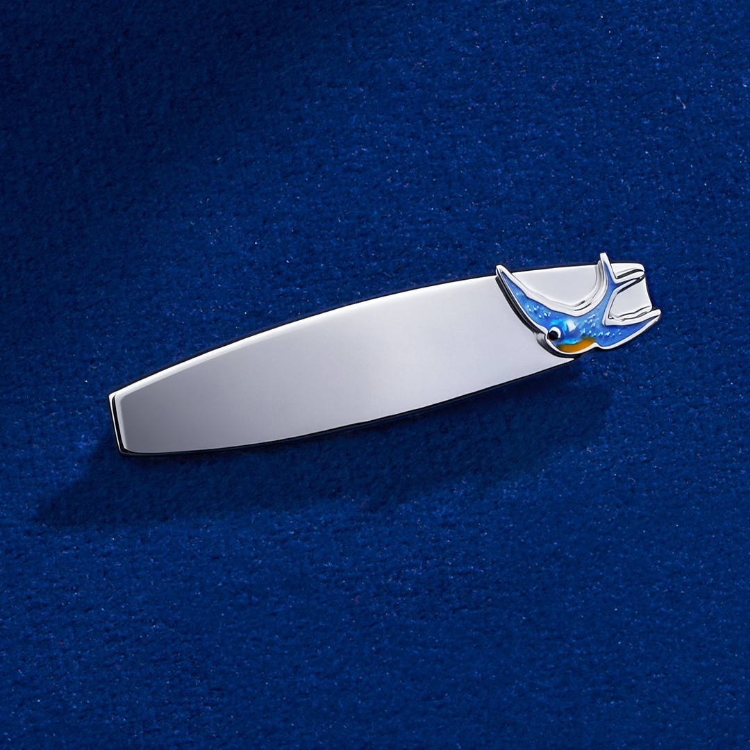 Flat lay view of the Wallace Bishop Bluebird of Happiness ID Plate Brooch in Sterling Silver, reference 49BRBB01, measuring 33mm in length, laid flat. The engravable plate features a bluebird finished in blue enamel.