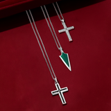 Front-on view of three Wallace Bishop gents pendants in sterling silver, each on a 650mm (approximately 25.6 inch) chain: the Cross Gents Pendant, reference 49NRP002, 41.50mm in length, with a rope design and a polished finish and a parrot clasp, , 47.20mm in length, with a polished face and a rope detail around the edge and a parrot clasp, the Malachite Arrowhead Gents Pendant, reference 4UNKMLSS1, 14.60mm in length, with a natural green malachite in an arrowhead