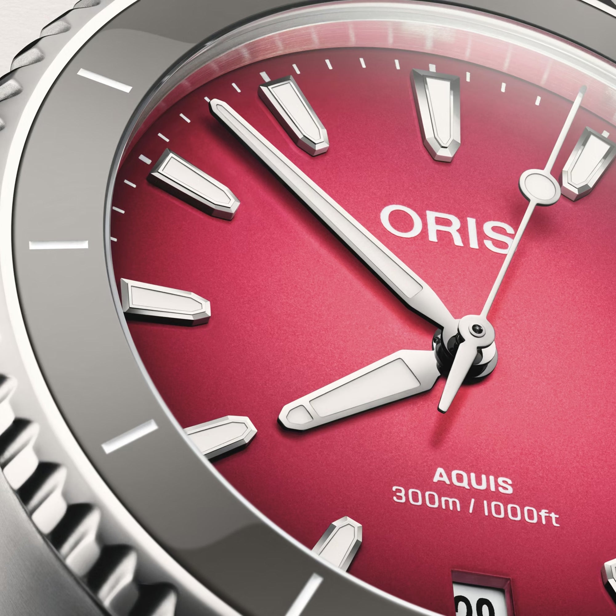 Close-up of Oris Aquis Date Taste of Summer gradient pink-red sunburst dial with date window and ceramic rotating bezel