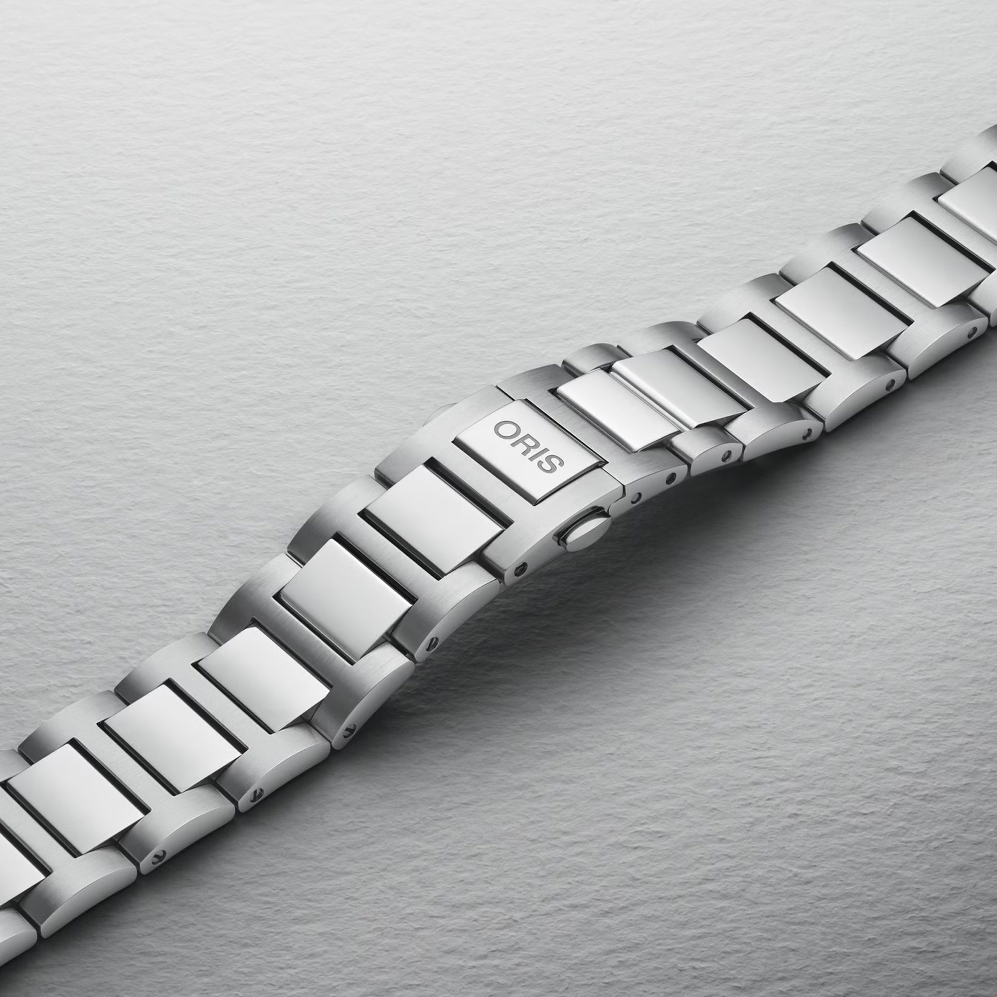 The 40mm stainless steel case sits confidently on the wrist, showing the black dial and oversized screw-down crown at the 3 o'clock position. The H-link bracelet fits closely and comfortably against the skin.
