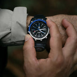 Luminox RECON Nav Spec Men's 46mm Quartz GMT Watch XL.8833 worn on the wrist to show its size and fit. This RECON Nav Spec watch features a black dial with blue accents, a two-tone rotating bezel and a lightweight CARBONOX™ case on a black rubber strap.