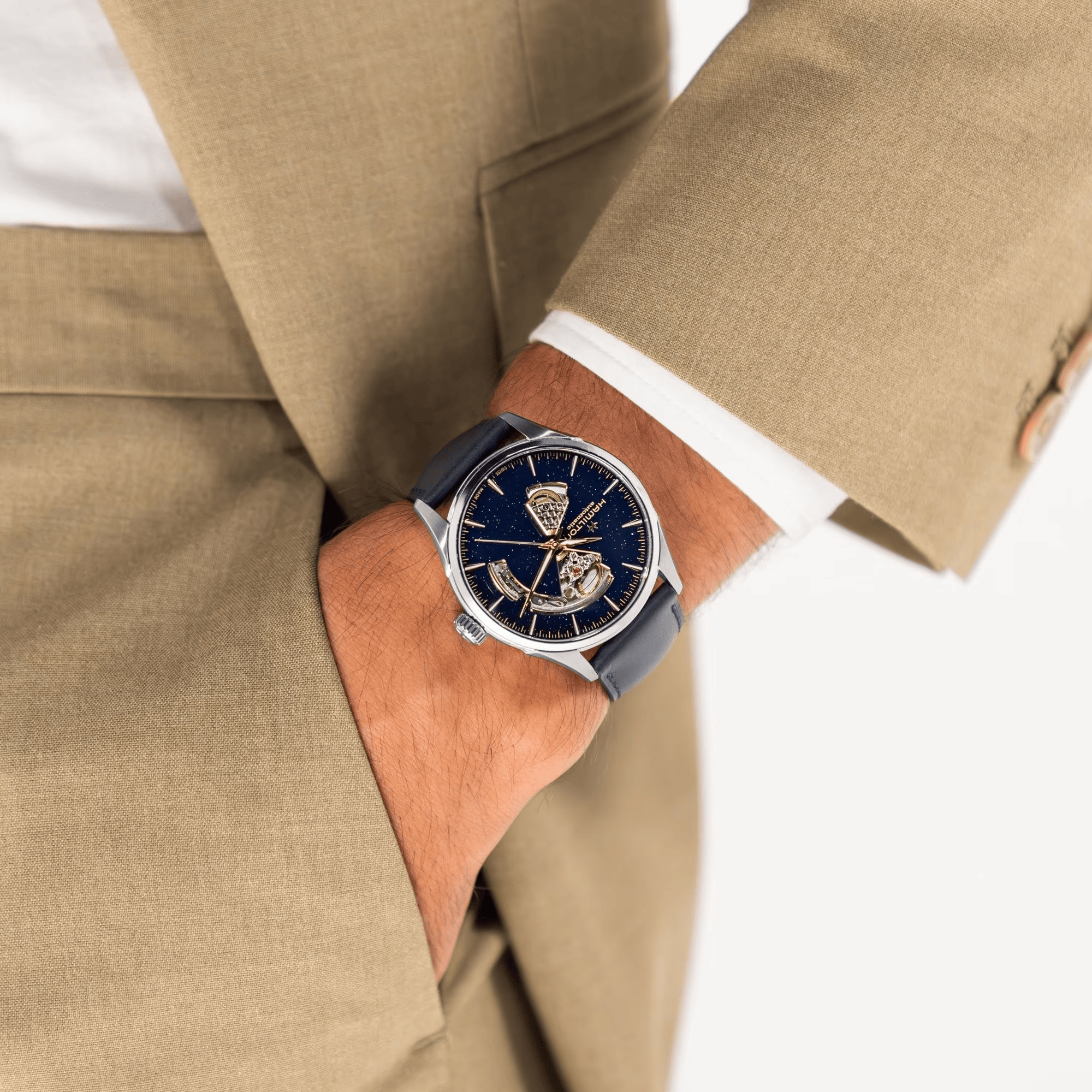 Man wearing A Hamilton Jazzmaster Men's 42mm automatic watch with a midnight blue dial and a blue leather strap.