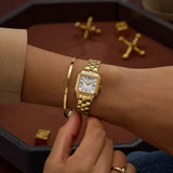 Gold Timex watch on a wrist with a white dial