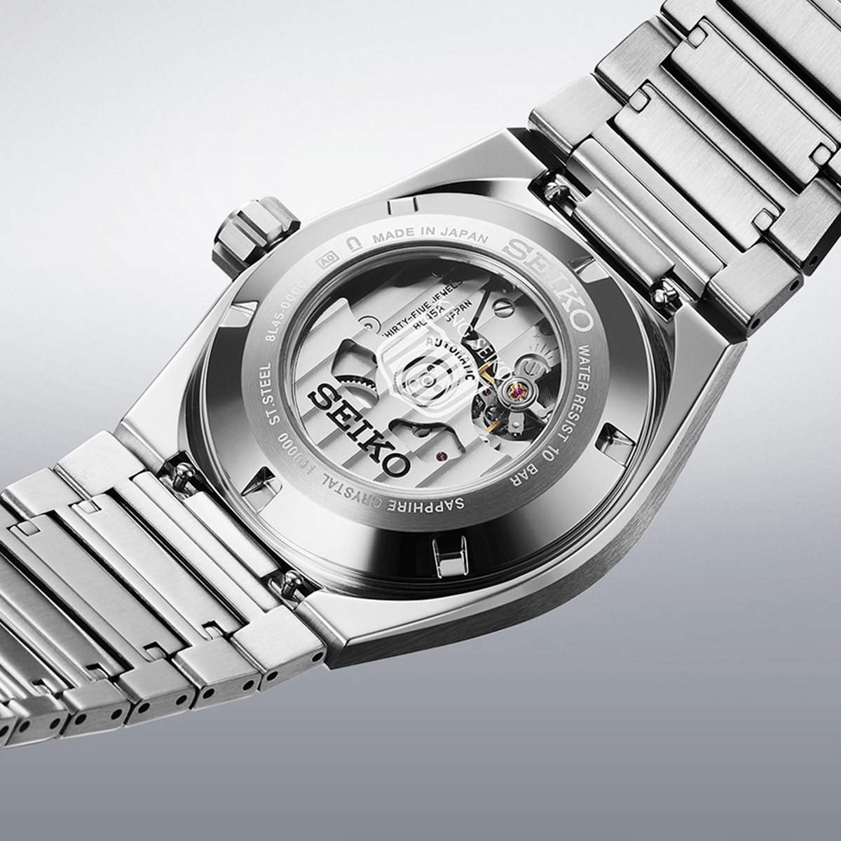 The King Seiko VANAC Men's 41mm Automatic Watch SLA085J is fitted with a stainless steel bracelet secured by a deployment clasp with push-button release. The screw-down, see-through case back reveals the automatic Calibre 8L45 movement.
