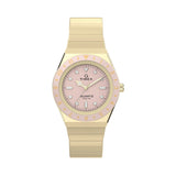 Gold-tone Timex Q Mini women’s watch with a pastel pink analog dial, luminous markers, 30mm stainless steel case, and matching expansion bracelet inspired by vintage 1970s styling.