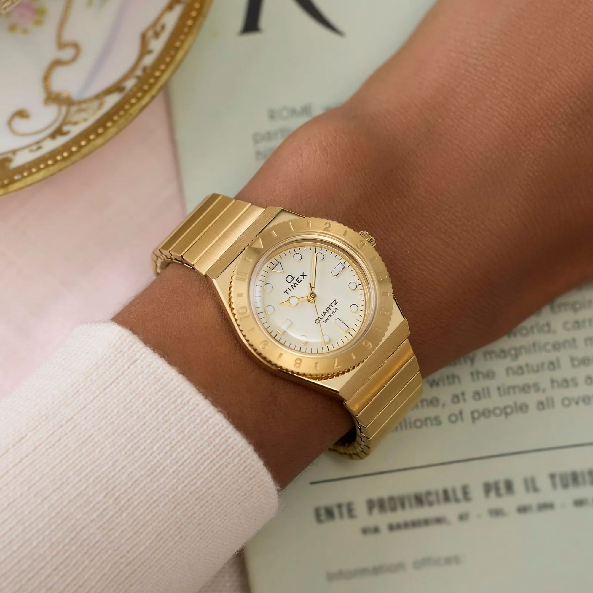 Gold-tone Timex Q Mini women’s watch featuring a 30mm stainless steel case, cream analog dial, luminous hour markers, and a matching expansion bracelet with vintage-inspired styling - on wrist