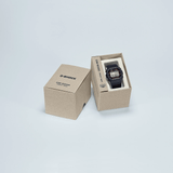 Casio G-SHOCK DW5000R-1A digital watch with stainless steel case, black resin band, screw back case, and classic square design in watch box