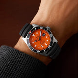 Timex Deepwater Reef 200 Titanium Automatic men’s watch with orange dial, black HNBR synthetic rubber strap, and brushed 41mm titanium case featuring a unidirectional dive bezel in a rugged professional dive watch design - on wrist