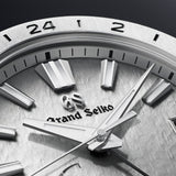 Close-up of a Grand Seiko watch face with metallic finish and brand logo.