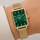 Close-up on-wrist detail of the Loyal Academy Gold PVD Women's Watch, reference 05A77FB01, highlighting the natural variation and texture of the genuine malachite dial. The mesh bracelet and mineral glass lens are visible against the wrist for scale.