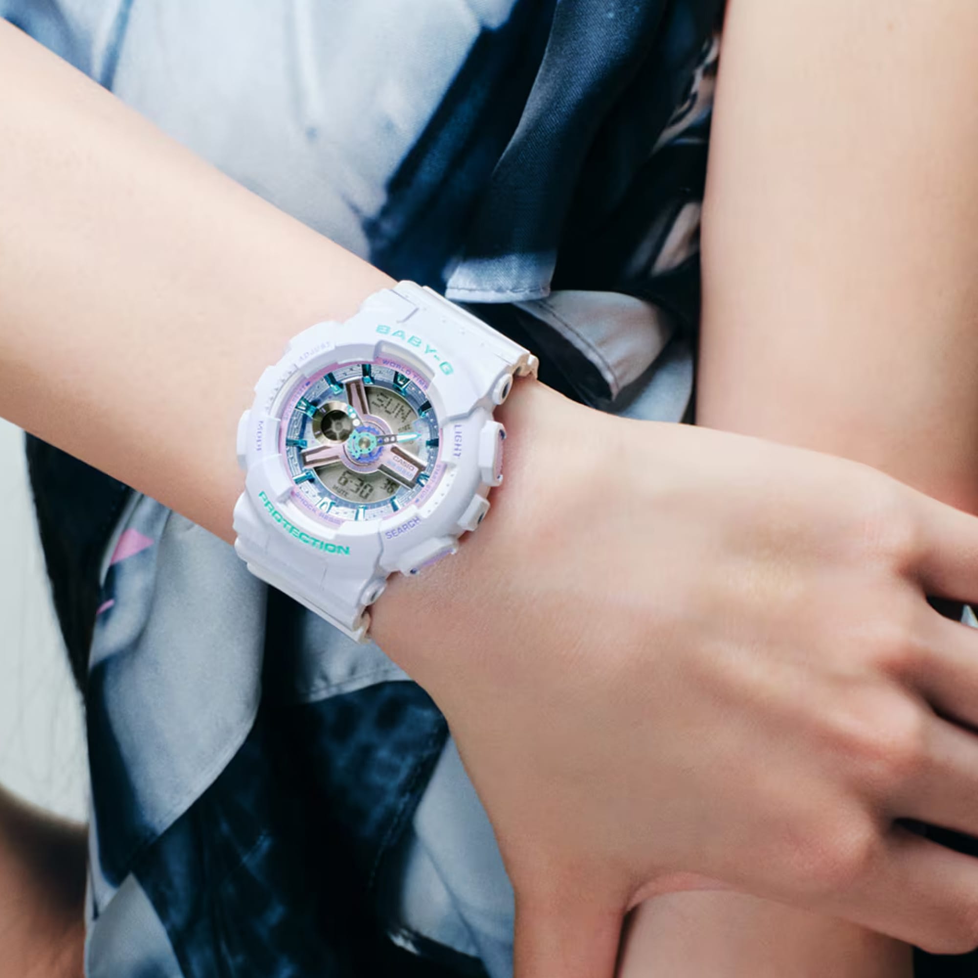 Casio Baby-G BA110MC-7A analogue digital watch worn on wrist, showing glossy white resin band and case with layered dial detail and metallic index markers.
