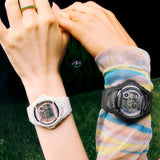 The Casio Baby-G Digital Women's Watch BG169GD-1D, 42mm case, worn alongside the Casio Baby-G Digital Women's Watch BG169GD-7D on a second wrist. The matte black and off-white colourways are shown side by side for comparison.