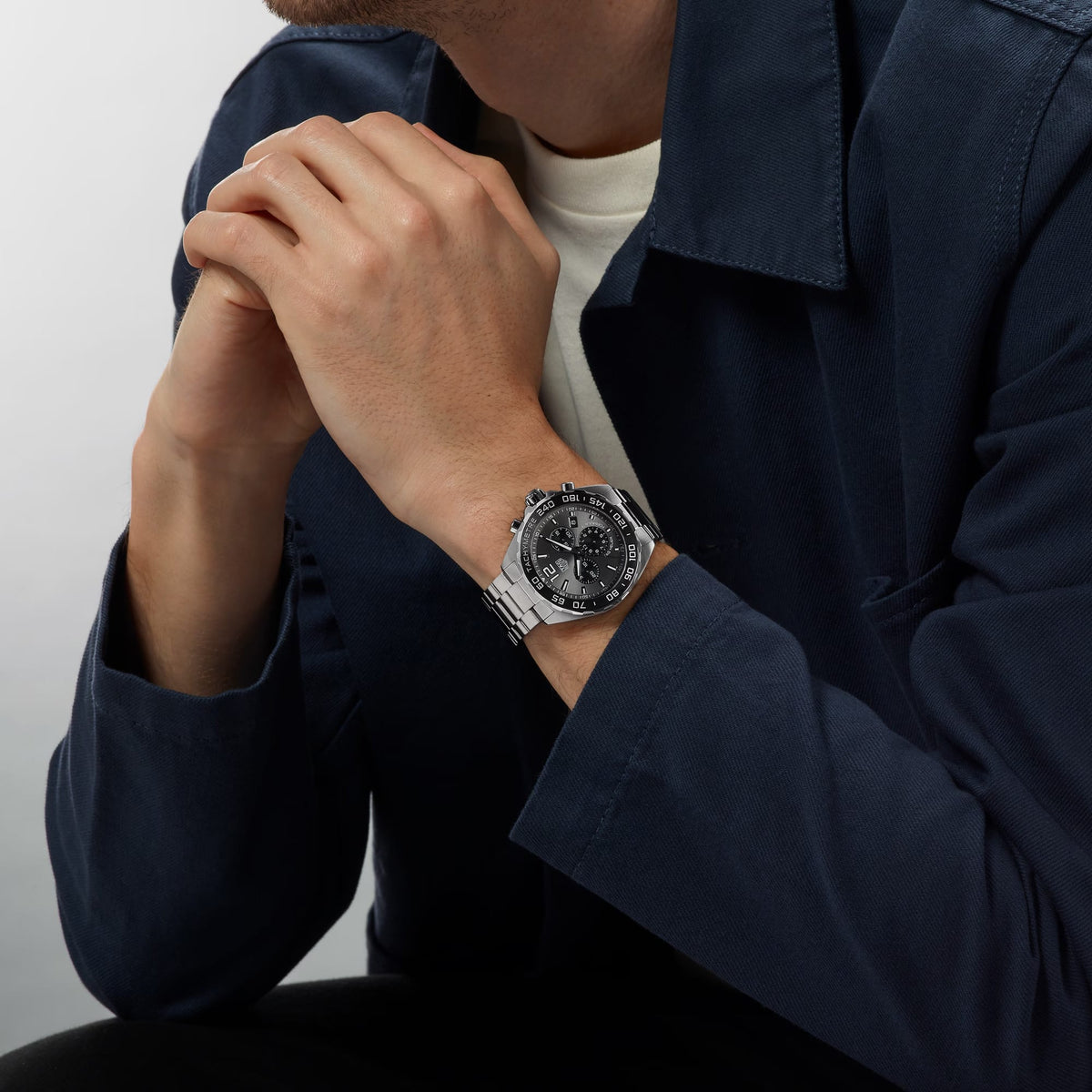 TAG Heuer Formula 1 Chronograph CAZ1011.BA0842 shown worn on the wrist, illustrating the case proportions and steel bracelet fit. The grey dial stands out against the sleeve in frame.