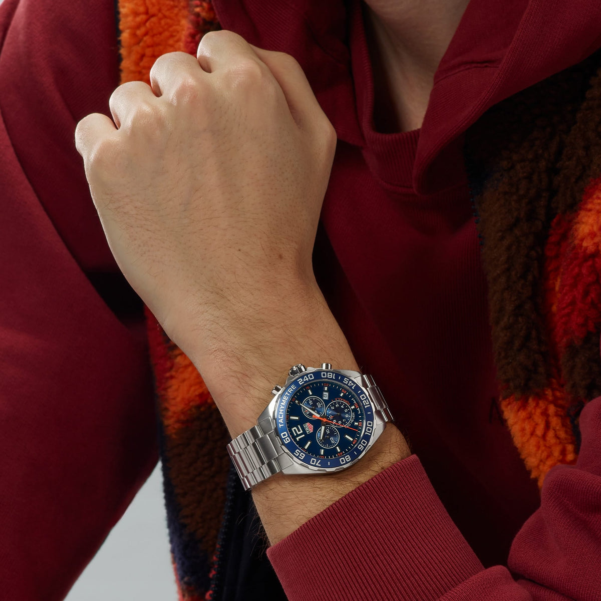TAG Heuer Formula 1 Chronograph CAZ1014.BA0842 shown worn on the wrist, illustrating the case proportions and steel bracelet fit. The blue dial stands out against the sleeve in frame.