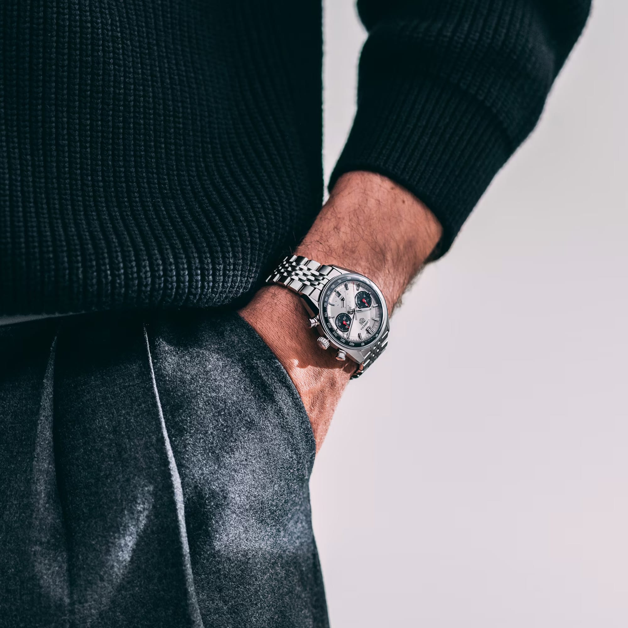 TAG Heuer Carrera Chronograph CBS2216.BA0048 shown worn on the wrist, illustrating the case proportions and steel bracelet fit. The silver dial stands out against the sleeve in frame.