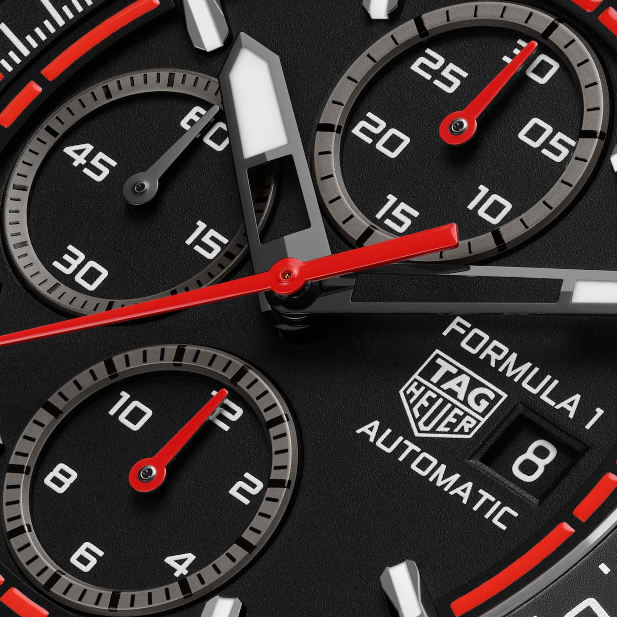 Close up of Dial of ablack TAG Heuer Formula 1 Chronograph watch with a red strap and red accents on the watch face.