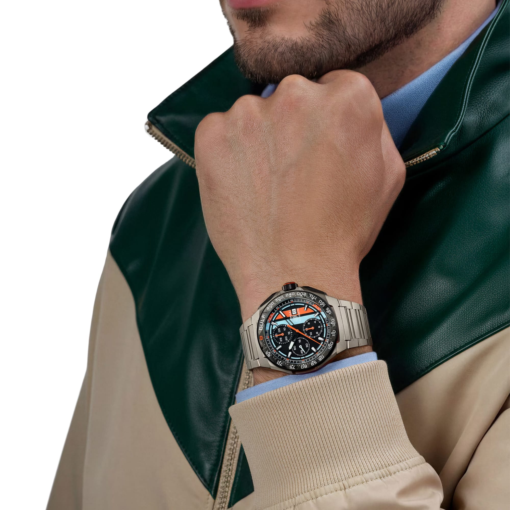 TAG Heuer Formula 1 Chronograph x Gulf CBZ208B.BF0009 shown worn on the wrist, illustrating the case proportions and titanium bracelet fit. The Gulf blue and orange dial stands out against the sleeve in frame.
