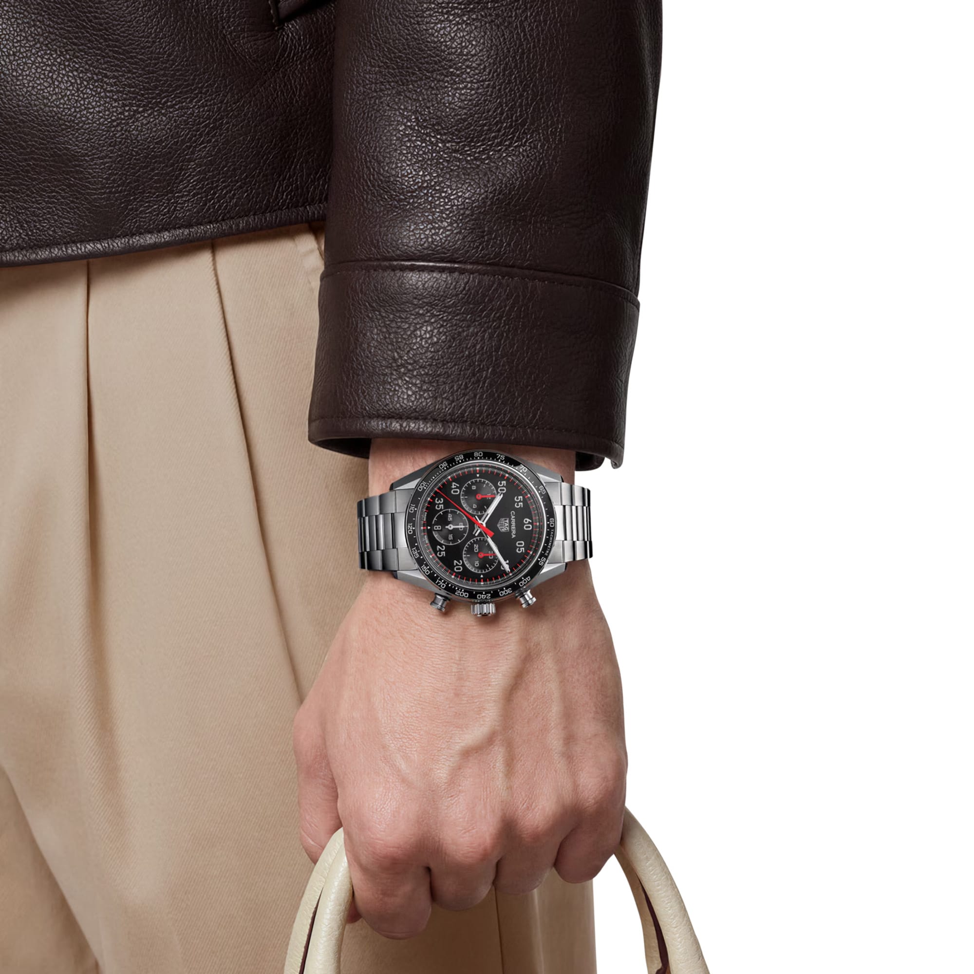 TAG Heuer Carrera Chronograph Sport CDB2110.BA0054 shown worn on the wrist, illustrating the case proportions and steel bracelet fit. The black dial stands out against the sleeve in frame.