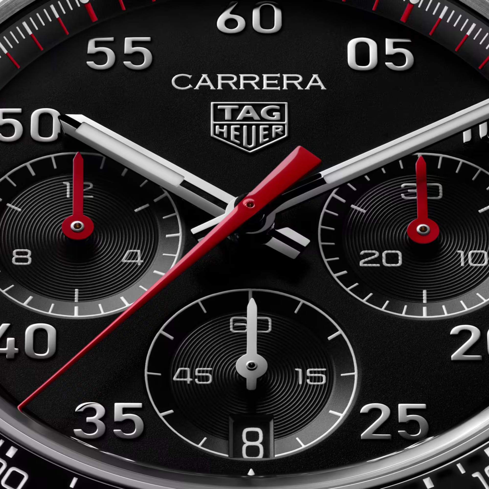 TAG Heuer Carrera Chronograph Sport CDB2110.BA0054 captured in extreme close-up on the black opalin dial, highlighting the red-lacquered chronograph hands and silver numerals. The Super-LumiNova-filled markers sit against the black dial surface.