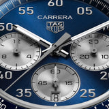 TAG Heuer Carrera Chronograph Sport CDB2111.FC8378 captured in extreme close-up on the blue circular-brushed dial, highlighting the silver numerals and Super-LumiNova-treated hands. The silver azuré counters sit against the blue dial surface.