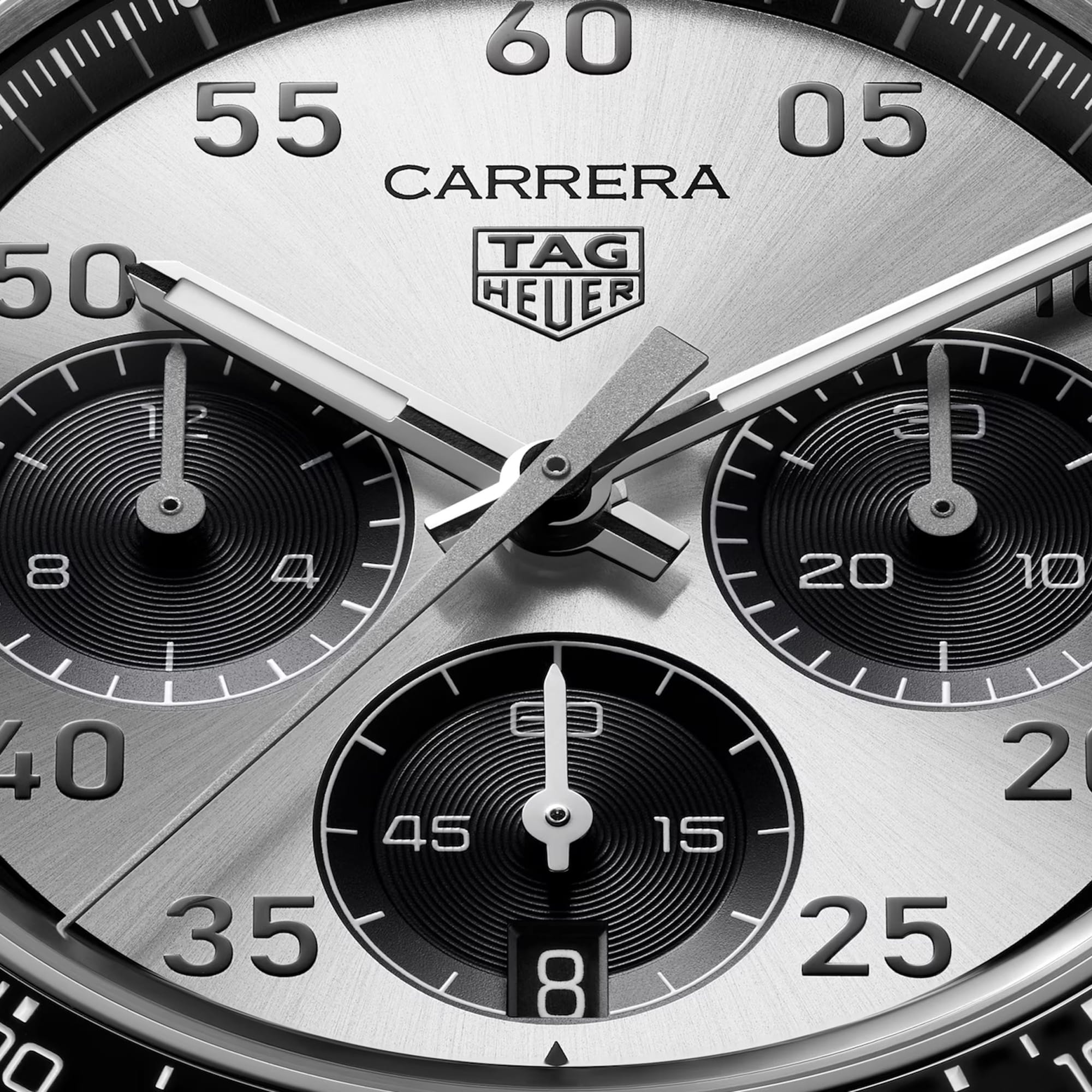 TAG Heuer Carrera Chronograph Sport CDB2113.BA0054 captured in extreme close-up on the silver sunray-brushed dial, highlighting the grey-lacquered chronograph hands and black numerals. The Super-LumiNova-treated hands sit against the silver dial surface.
