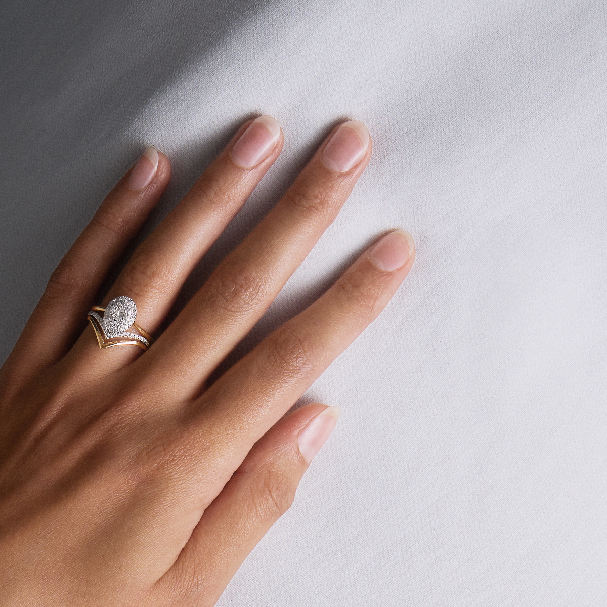 Hand Wearing Engagement ring with Wishbone Shaped Yellow and White Gold eternity band