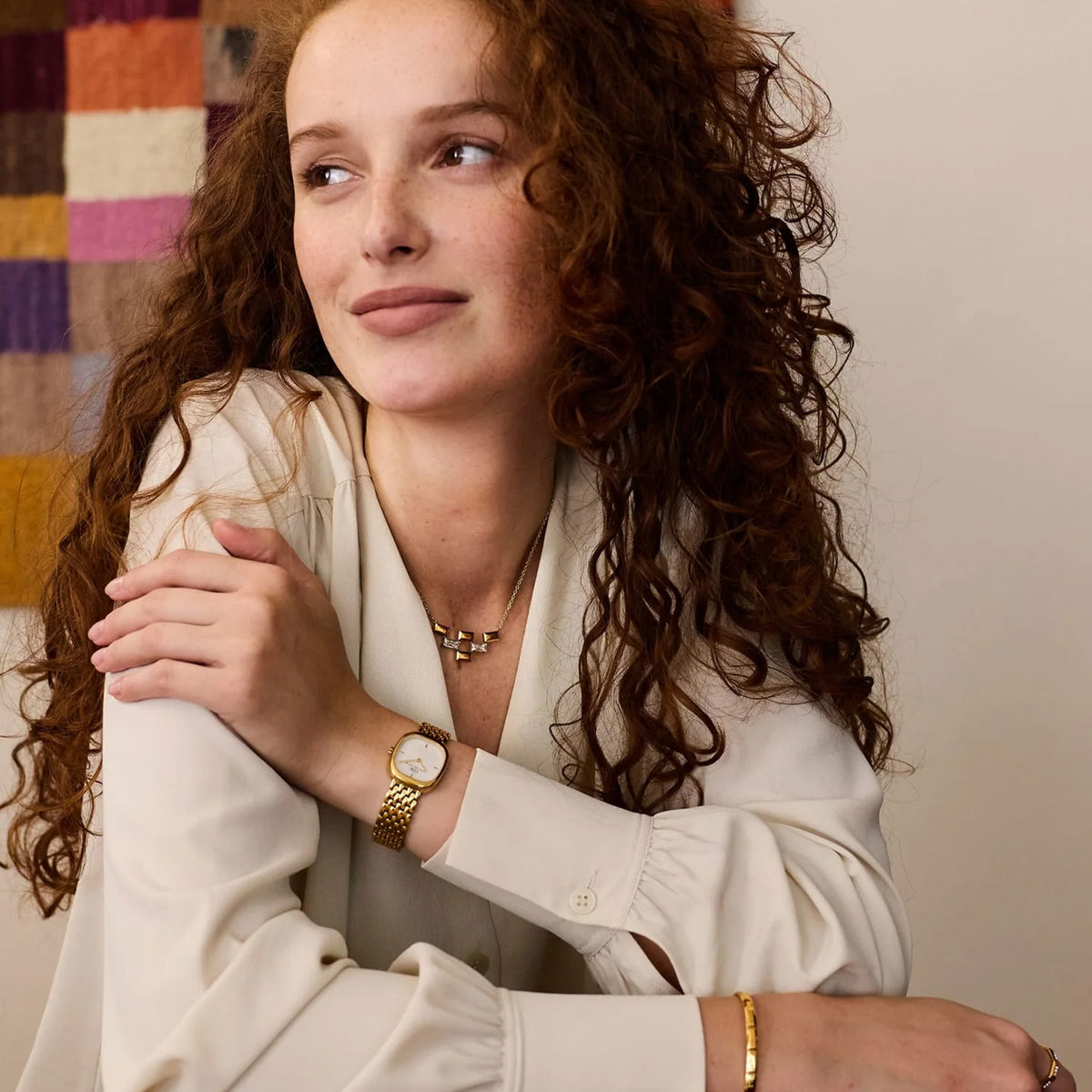 The Daniel Wellington Corta Grain-Link Women’s 24mm Quartz Watch DW00100993 worn on the wrist to show its petite size and fit. The compact gold cushion case and grain-link bracelet sit neatly on smaller wrists.