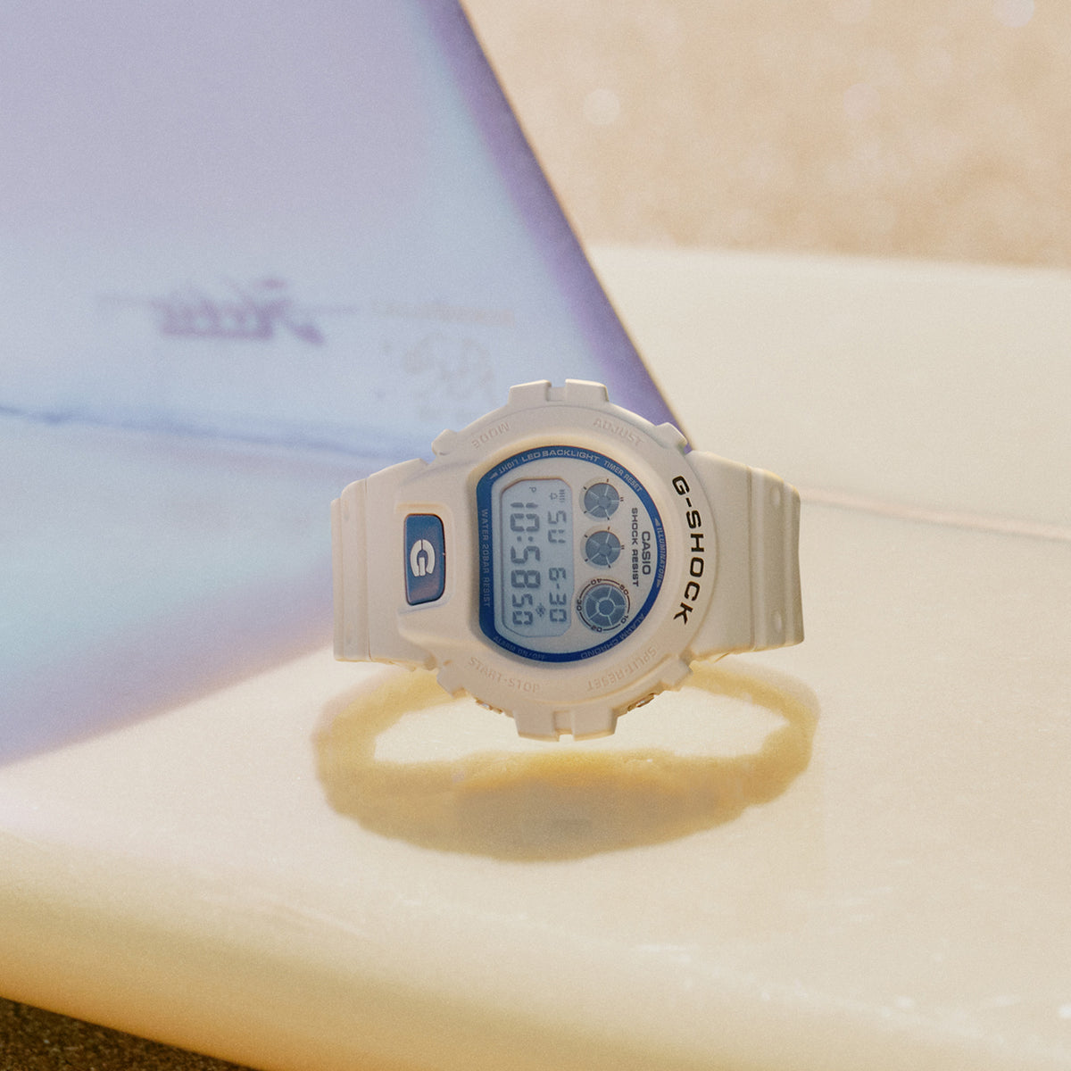 Lifestyle shot of the Casio G-SHOCK Quartz Men's Watch DW-6900HDS-7 styled in an everyday casual setting. The white and blue colourway is shown in a natural, real-world context.