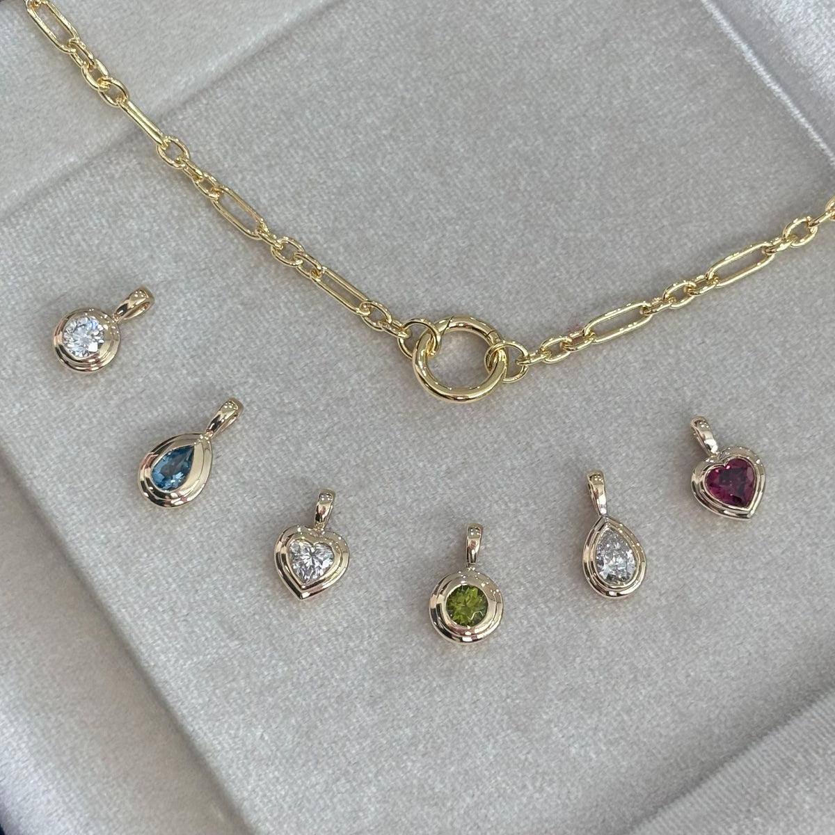 Six Wallace Bishop double bezel pendants in 9ct Yellow Gold shown in a row with chain