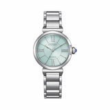 Close-up of the Citizen L May Bells EM1070-83L face, showing the pale green dial with Roman numeral and baton markers and blue cabochon crown. The stainless steel case and sapphire crystal are visible.