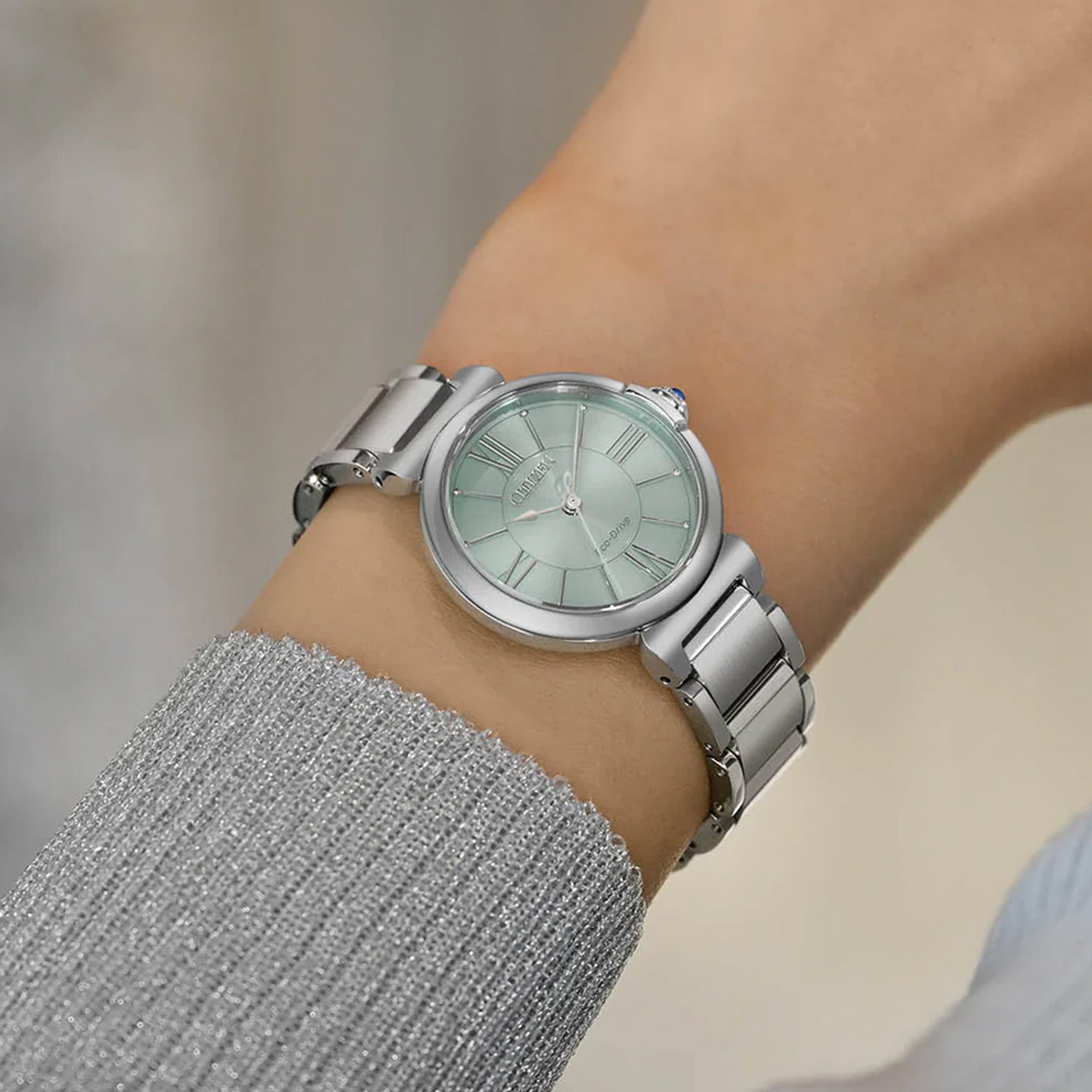 The EM1070-83L worn on the wrist, highlighting its slim 29.5mm case and 8.3mm profile. The stainless steel bracelet sits neatly for everyday wear.