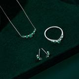 Front-on view of three Wallace Bishop Created Emerald & Lab-Grown Diamond Chevron pieces in Sterling Silver: the 0.04 TDW Pendant, reference LG33EME03, the 0.04 TDW Climber Earrings, reference LG33EME04, and the 0.04 TDW Ring, reference LG33EME02O. Each piece features round created emeralds with small round lab-grown diamonds set between them.