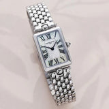 Frederique Constant Women's 28mm Stainless Steel Quartz Watch FC-200MPW2AC6B styled in a lifestyle setting, reflecting its elegant, Art Deco-inspired design suited to dressier occasions. The mother-of-pearl dial and polished stainless steel case complement a refined, feminine look.