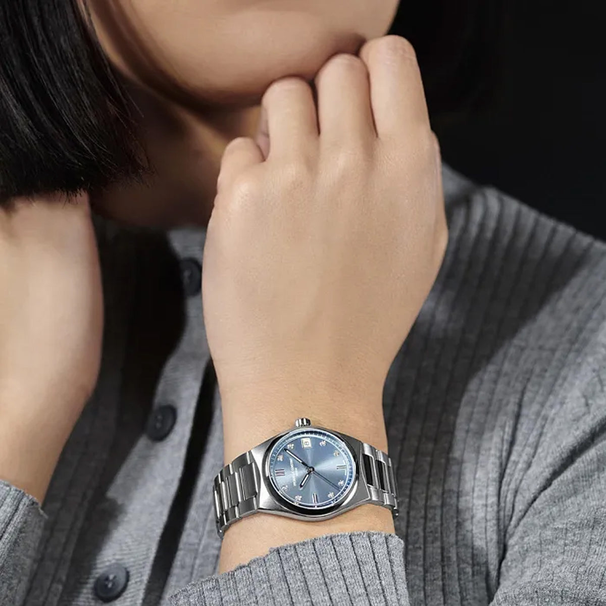 Frederique Constant Highlife Women's 31mm Quartz Stainless Steel Watch FC-240LND2NH26B worn on the wrist, demonstrating the fit of its 31mm case and integrated stainless steel bracelet. The watch can also be worn on the included blue rubber strap for a sportier look.