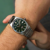 Frederique Constant Highlife Automatic COSC Watch FC-303GRS3NH6B worn on the wrist, demonstrating the comfortable fit of its 39mm case. The watch can be worn on its stainless steel bracelet or swapped to the included green nubuck leather strap.
