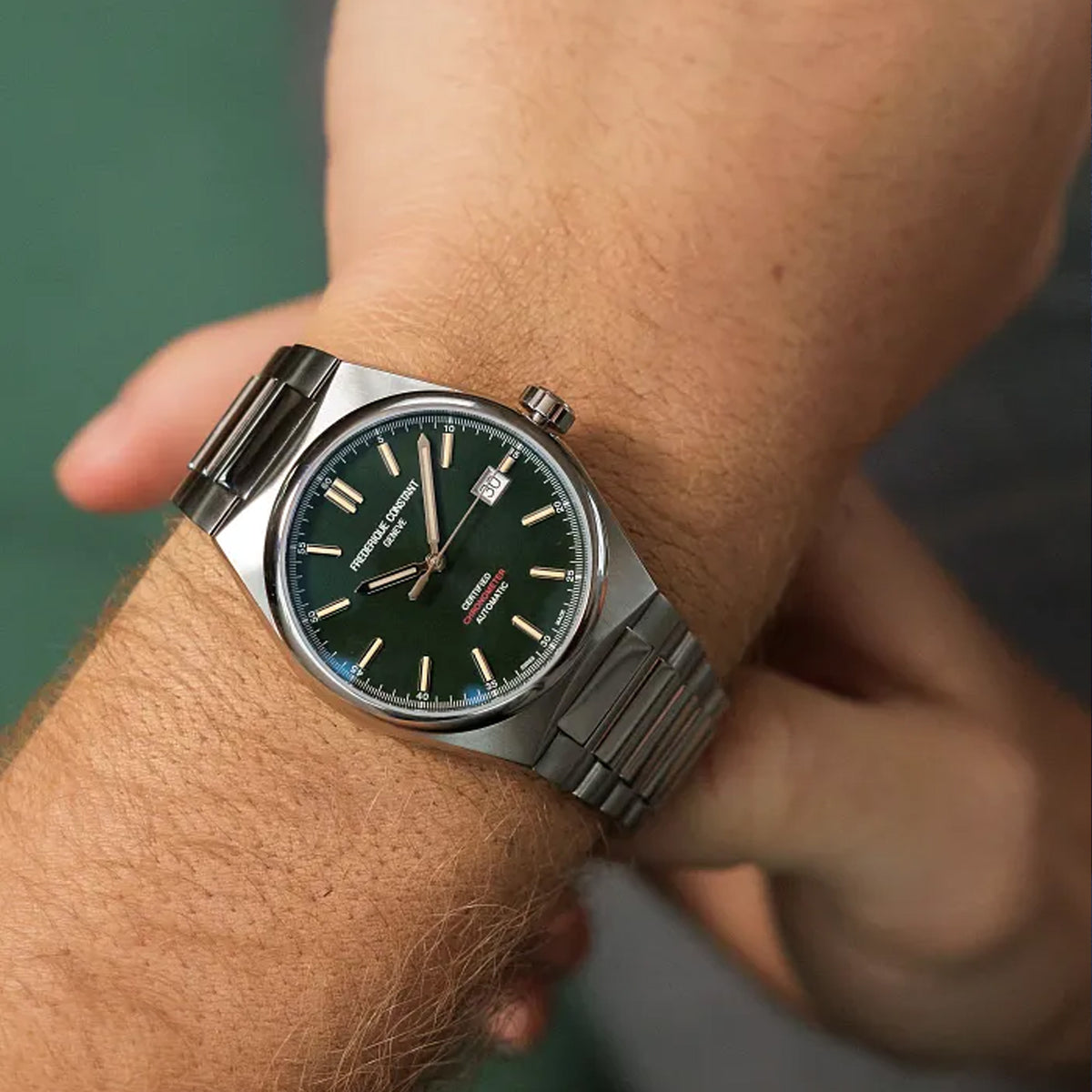 Frederique Constant Highlife Automatic COSC Watch FC-303GRS3NH6B worn on the wrist, demonstrating the comfortable fit of its 39mm case. The watch can be worn on its stainless steel bracelet or swapped to the included green nubuck leather strap.